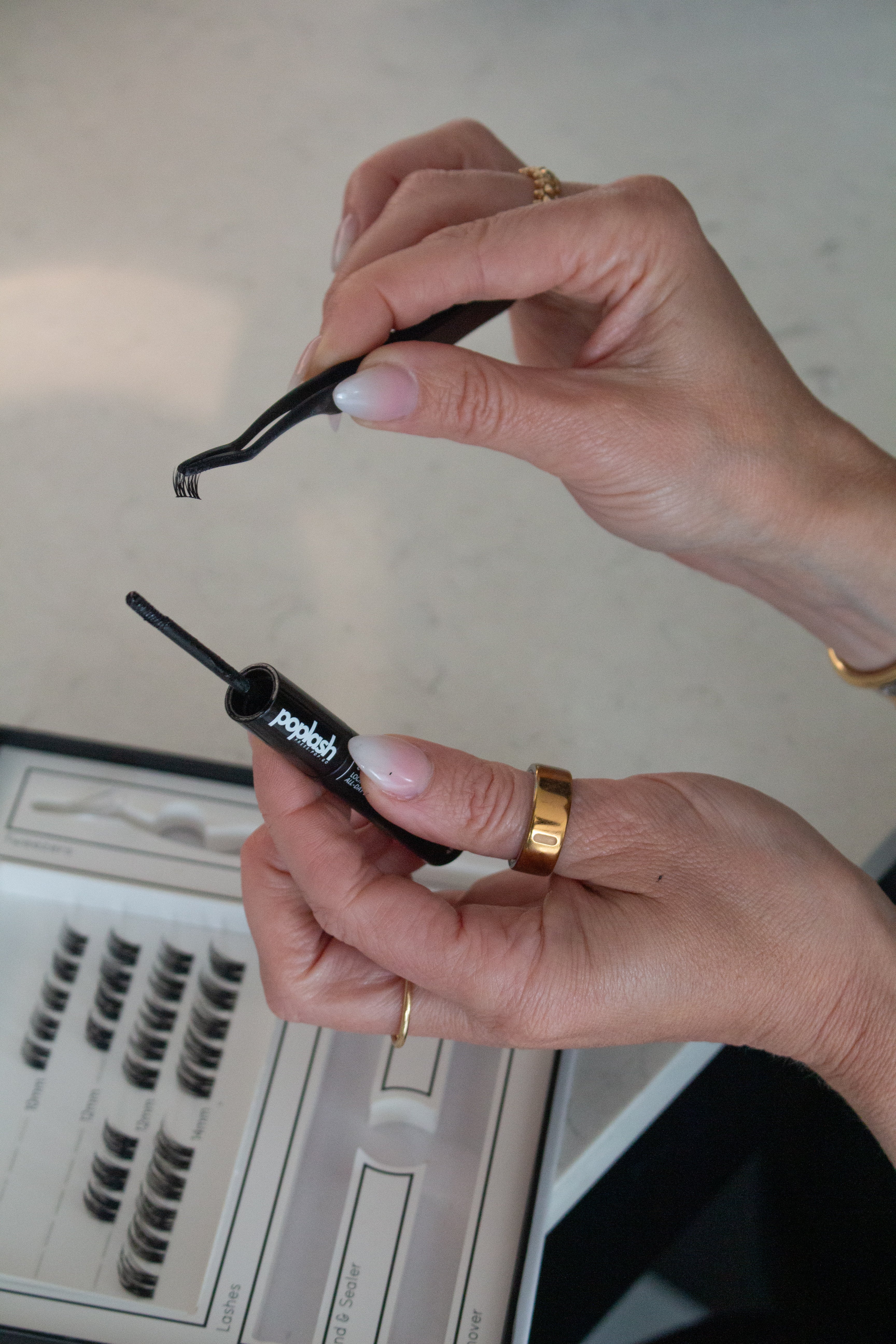 Person holding a lash extension tweezer and eyelash extension 